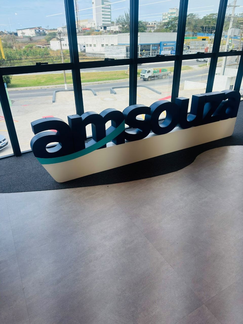 Logo Amsouza aplicado próximo a grandes janelas